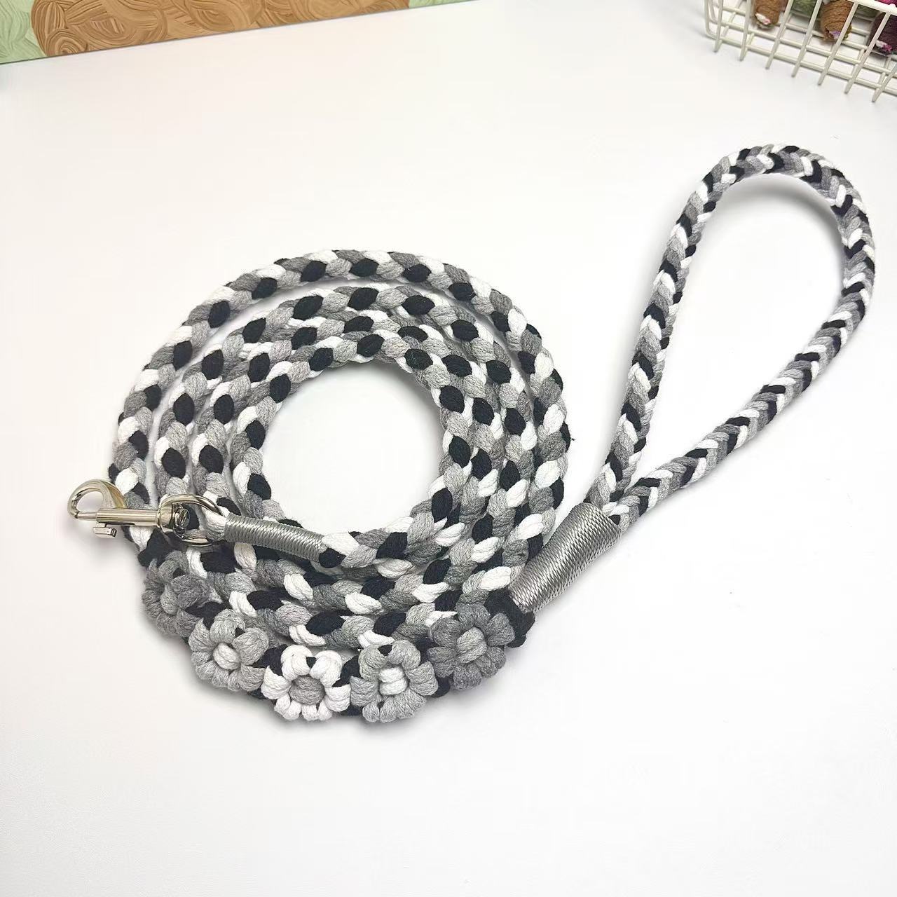 Black and gray five-flower handmade dog leash coiled together, displaying its overall design with a calm and elegant look.
