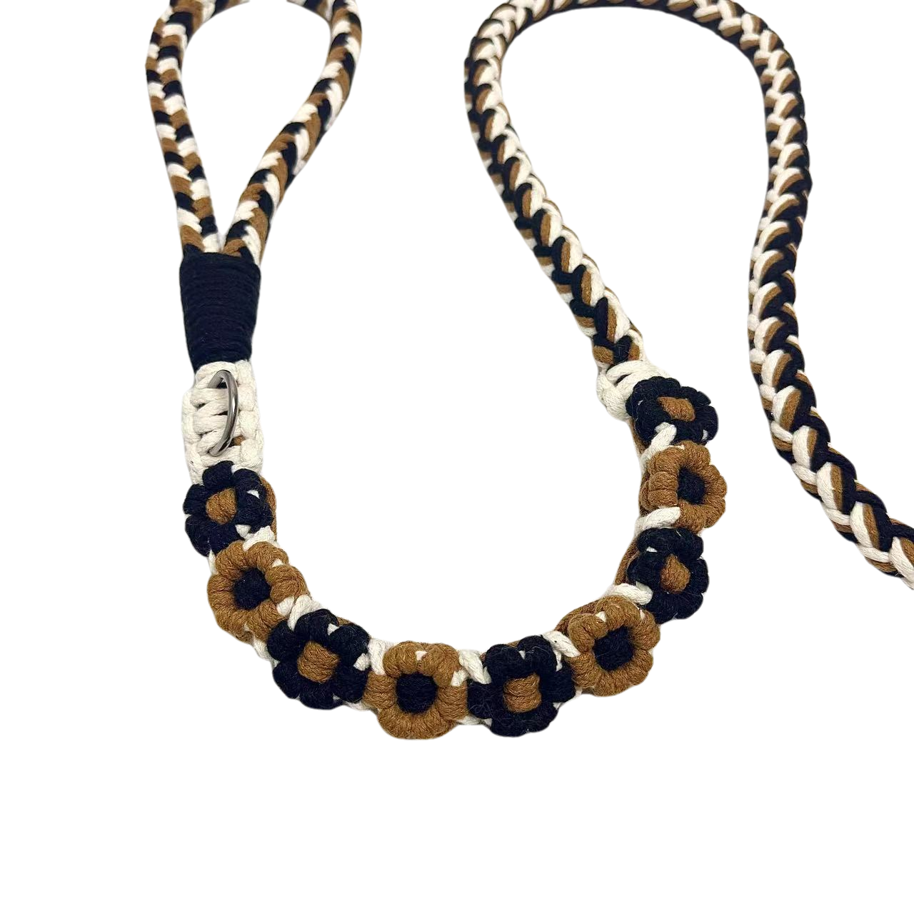 A detailed view of a black and brown handwoven dog leash with a charming floral design. The leash is elegantly placed on a textured white surface, highlighting its intricate craftsmanship and vibrant colors.