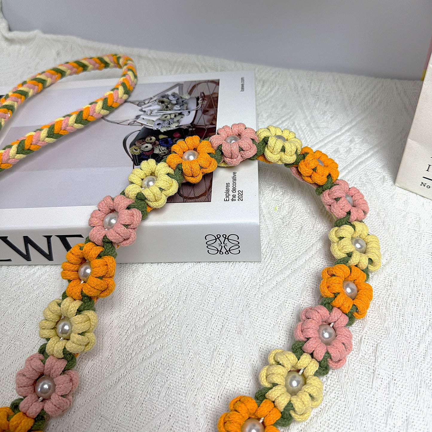 Dog leash decorated with numerous handcrafted flowers in natural yellow, orange and pink tones.