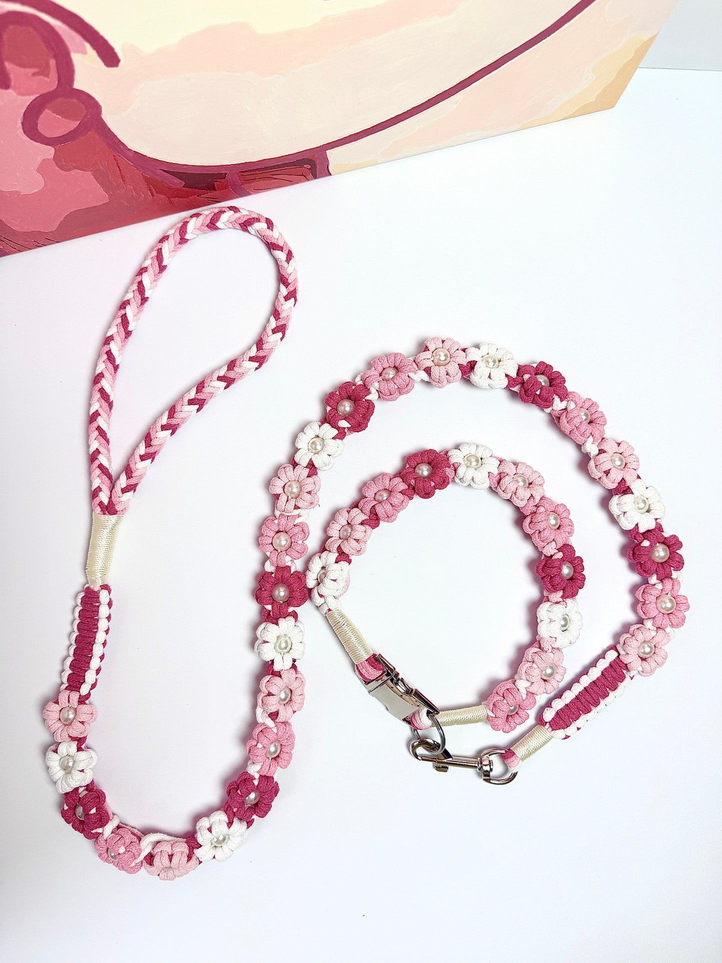 Handmade pink and white floral dog leash with a coiled design, paired with a matching collar. A stylish and practical choice for chic pet owners.