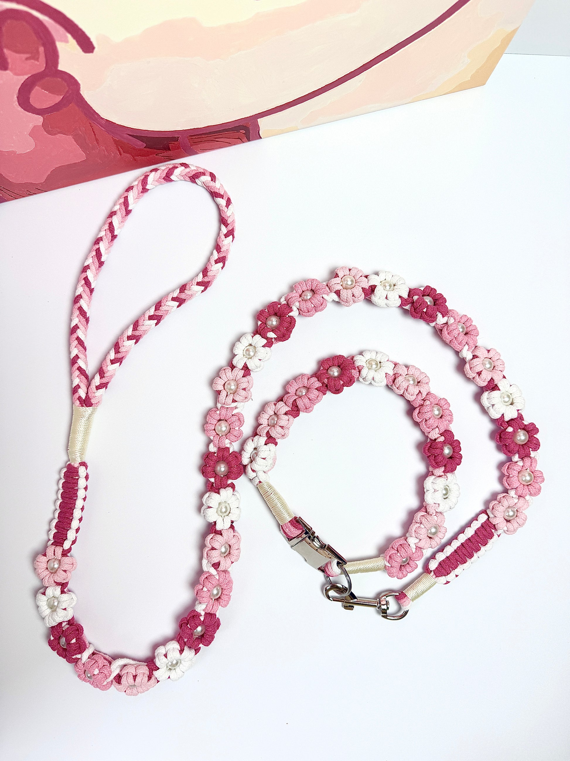 Handmade pink and white floral dog leash with a coiled design, paired with a matching collar. A stylish and practical choice for chic pet owners.