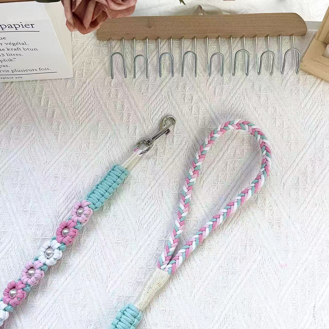 The soft handle and the clip of the handmade sakura-inspired dog leash, featuring multiple beautiful woven flowers.