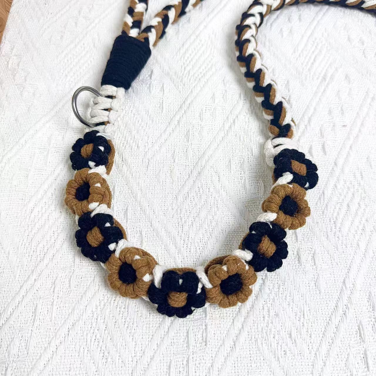 Handmade dog leash decorated with nine handcrafted flowers in steady black and brown tones.