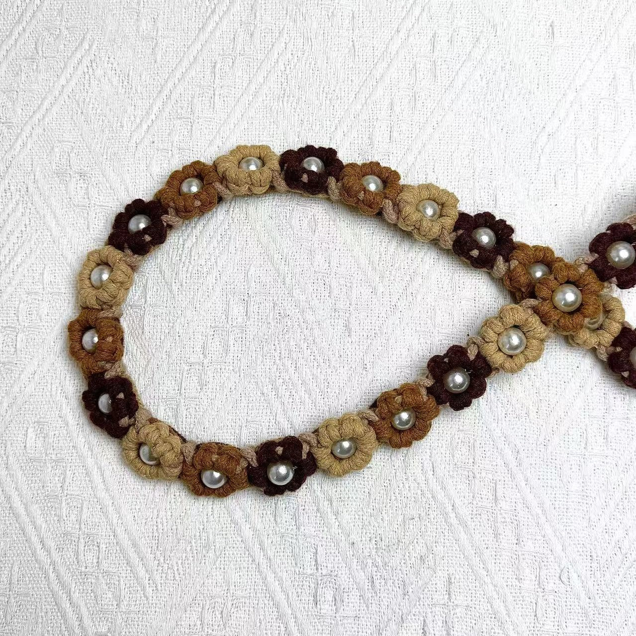 Dog leash decorated with numerous handcrafted flowers in stylish brown tones.