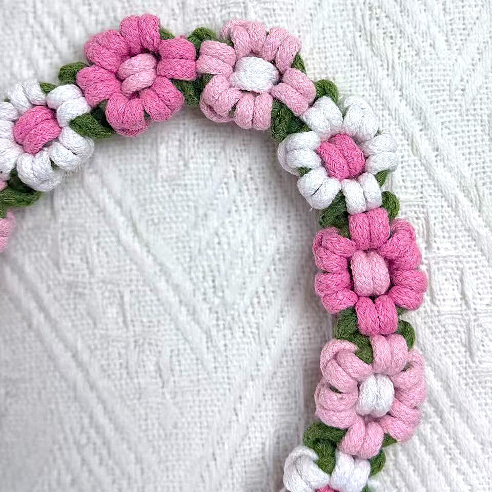 Handmade dog leash decorated with nine handcrafted flowers in vibrant pink and white tones.