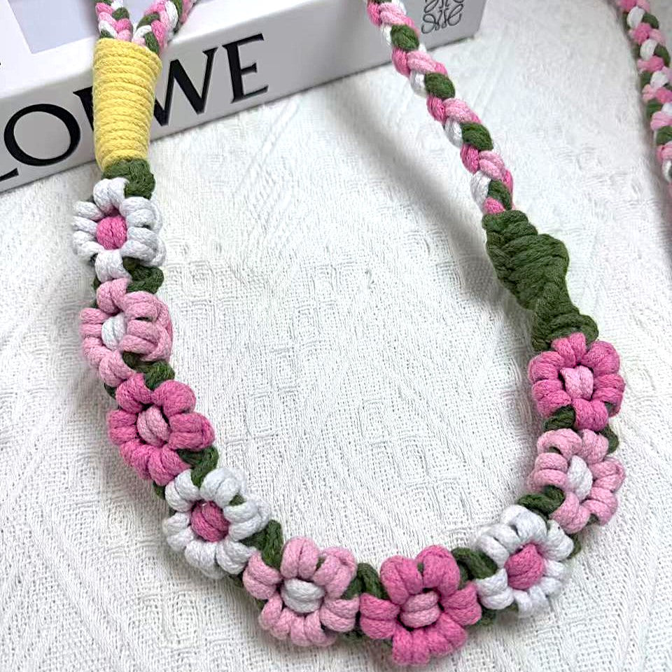 Handmade dog leash decorated with nine handcrafted flowers in vibrant pink and white tones.