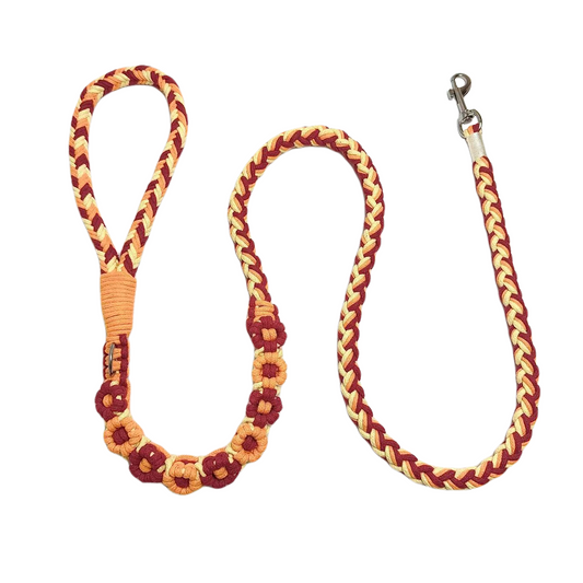 Orange and red nine-flower handmade dog leash laid flat, displaying its overall design with a vibrant and elegant look.