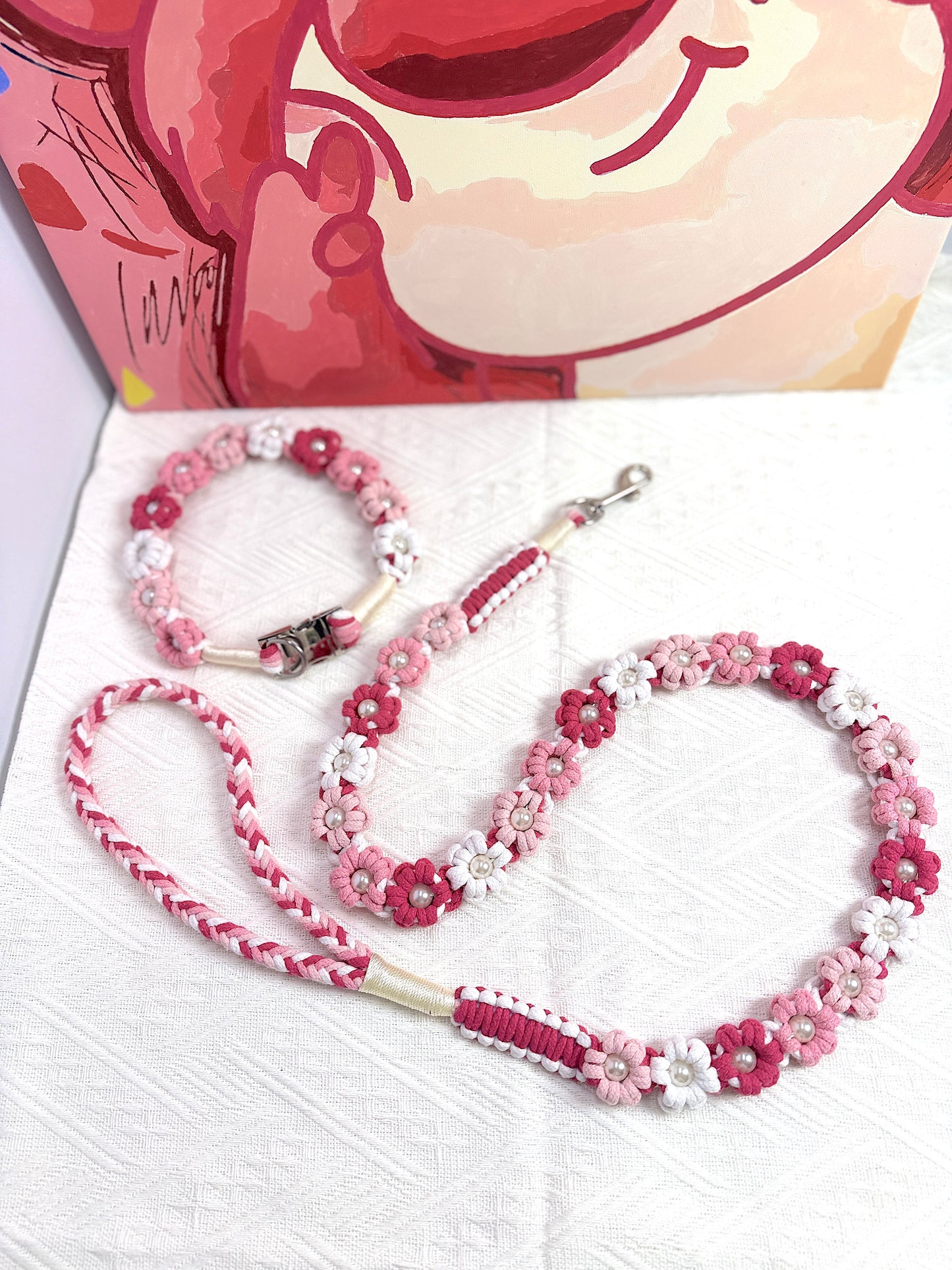 Handmade dog leash and collar with pink and white floral details, accented by pearl-like beads for an elegant touch.