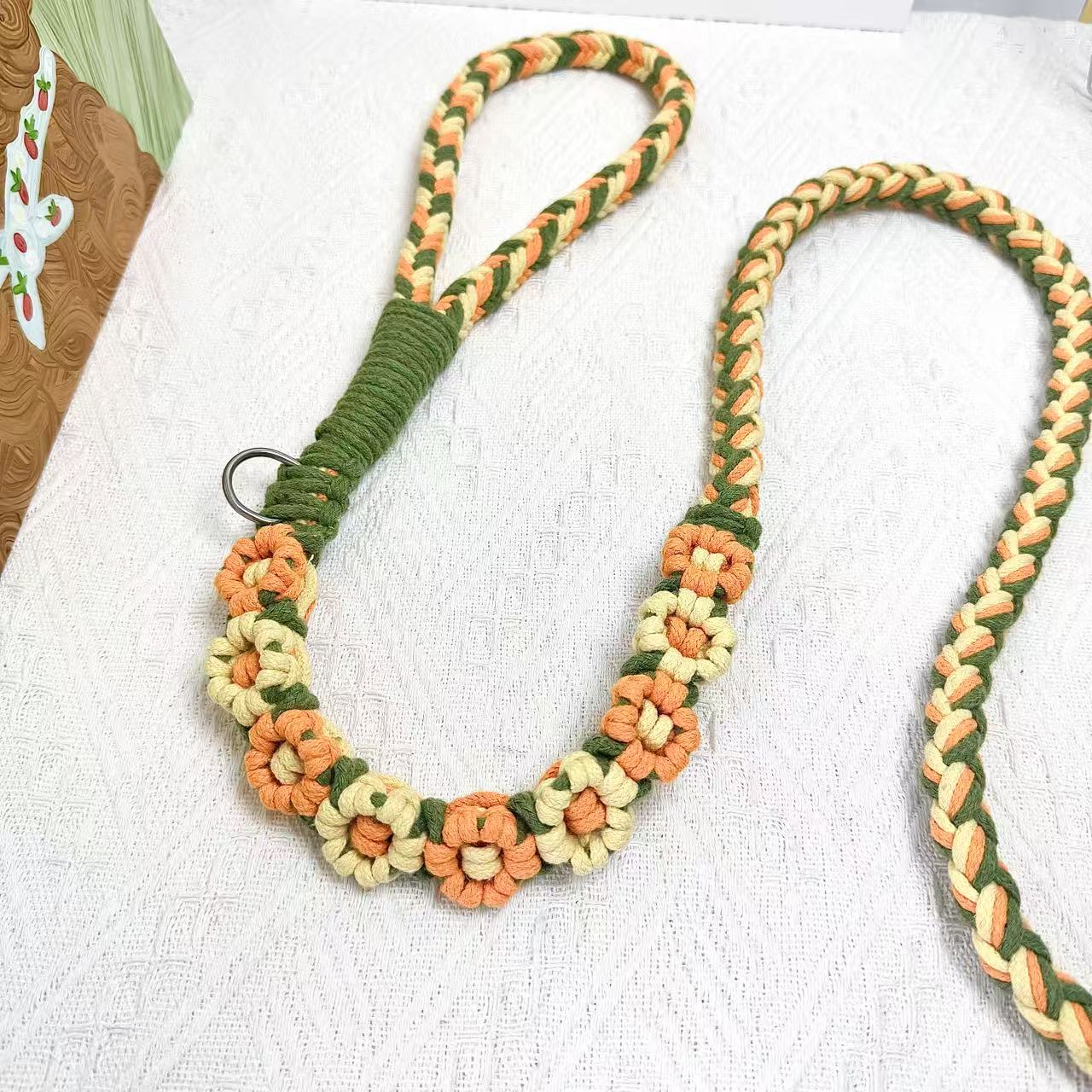 Handmade dog leash decorated with nine handcrafted flowers in elegant orange and yellow tones.