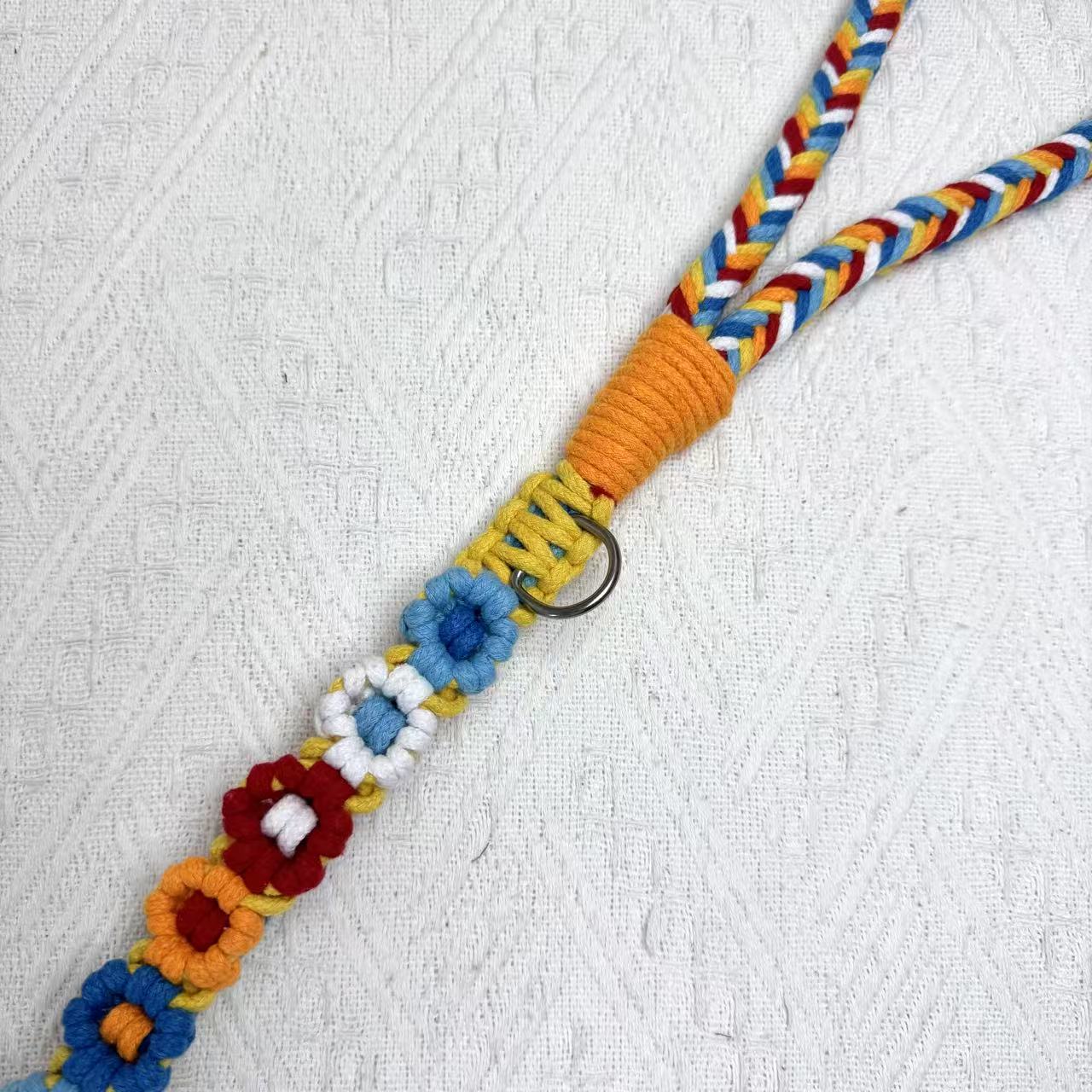 Handmade dog leash decorated with nine handcrafted flowers in vibrant red and blue tones.