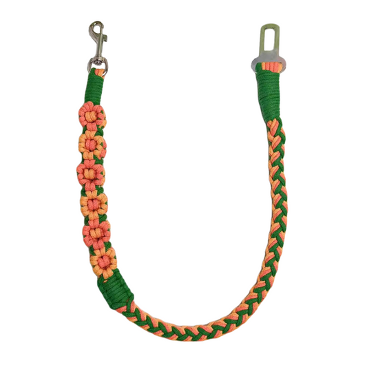 A handmade orange and green dog safety seatbelt featuring braided patterns and flower details, designed for durability and style.